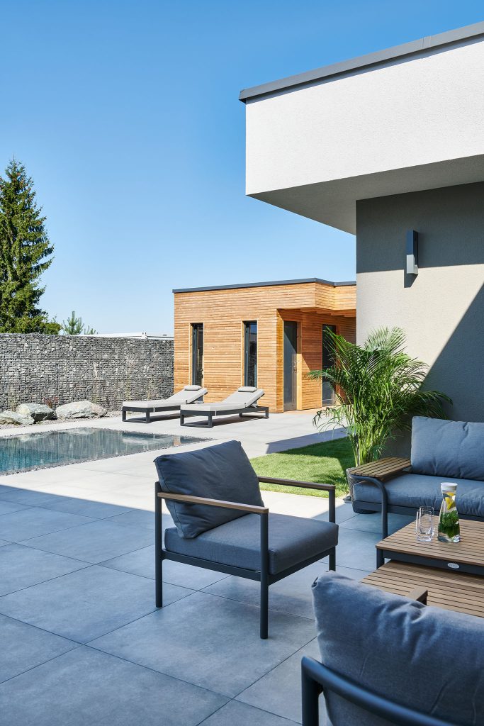 Zahradní terasa s posezením, bazénem a dřevěným zahradním domkem