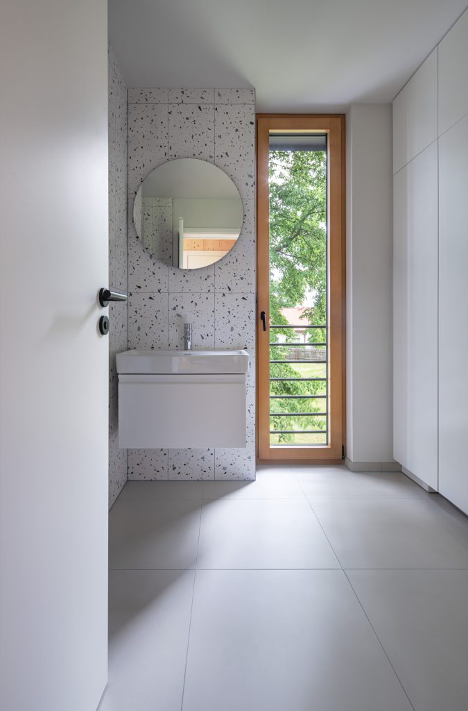 Koupelna s kulatým zrcadlem a výhledem do přírody