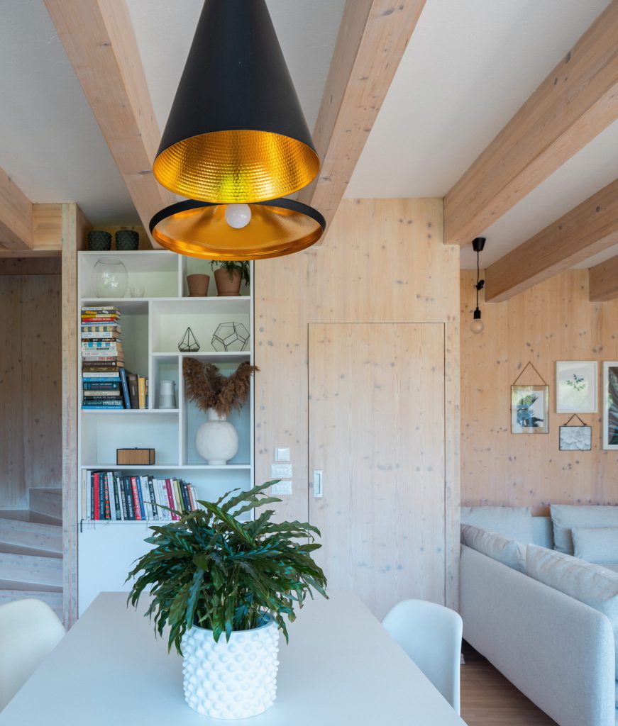 Interiér dřevostavby s CLT panely a vestavěnou knihovnou