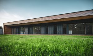 Moderní dřevostavba s dřevěnou střechou a pásovými okny na jižní straně