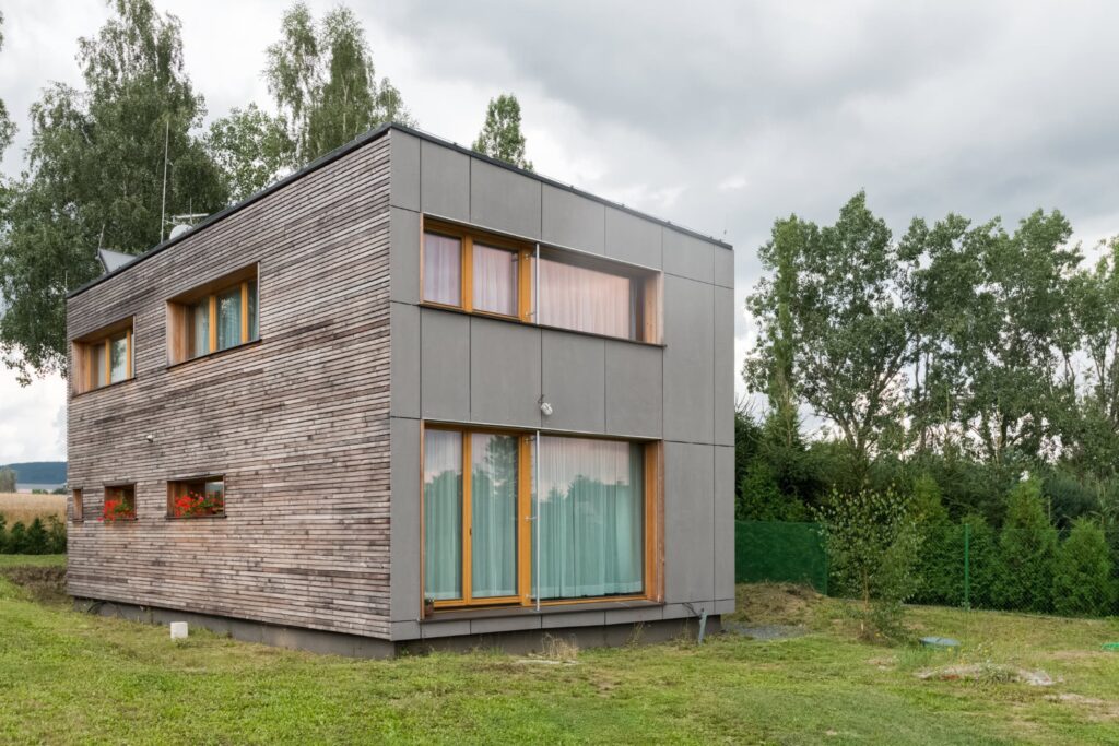 Kubický dvoupodlažní dům s dřevěnou fasádou a velkými okny