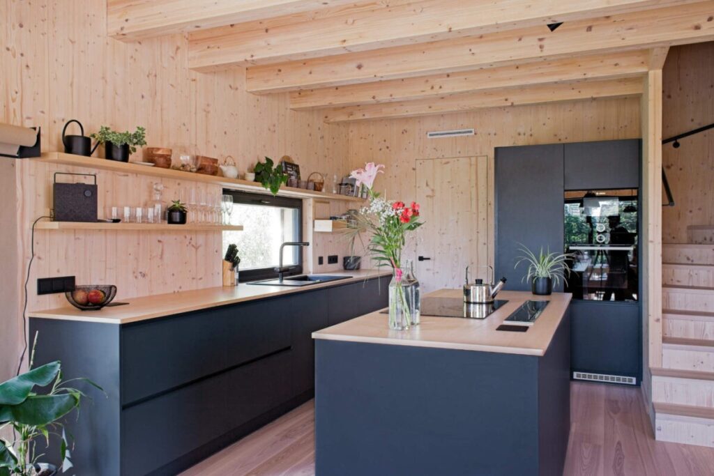 Moderní kuchyň s černou linkou, policemi a světlým dřevěným interiérem