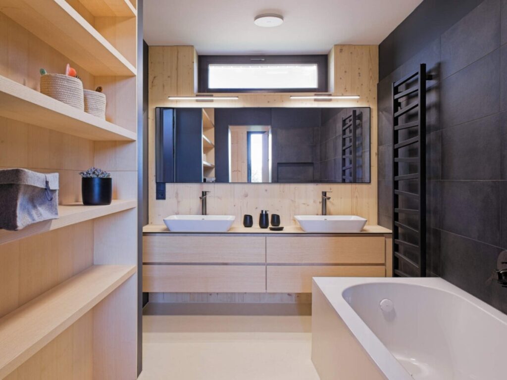Koupelna s dvojitým umyvadlem, vanou a dřevěnými policemi