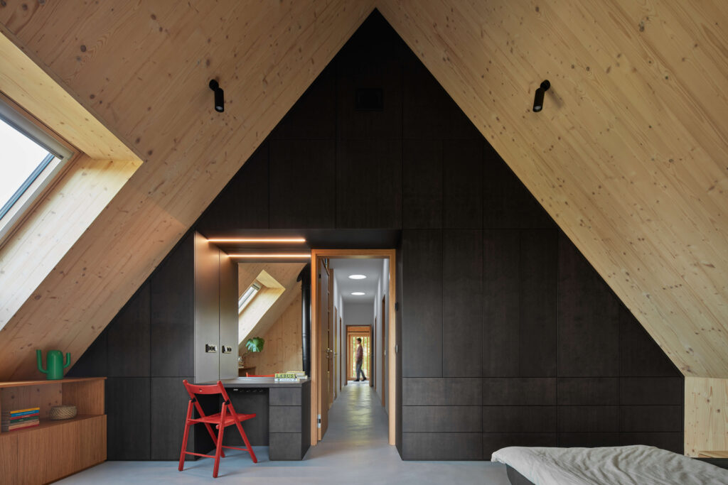 Ložnice v podkroví s tmavou dýhovou vestavbou a pohledovým CLT obkladem