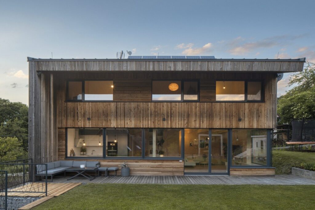 Dvoupodlažní dřevostavba z CLT panelů s dřevěnou fasádou a velkými okny