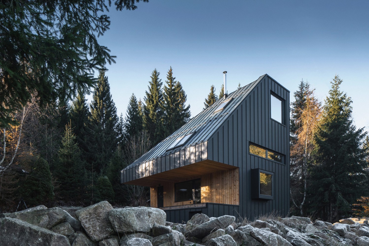Moderní horská chata navržená od NEW HOW architekti realizovaná firmou 3AE s antracitovou fasádou a výhledem do lesa