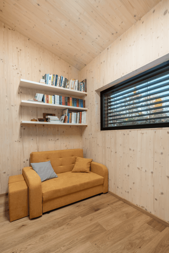 Pracovní kout s knihovnou a oknem v interiéru rodinného domu