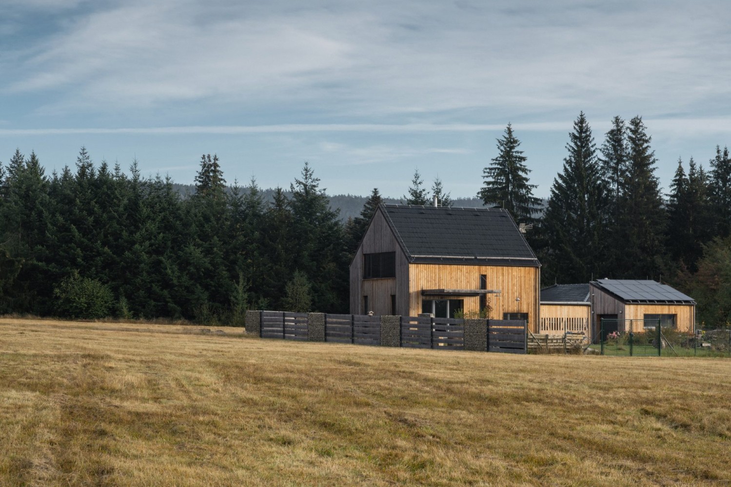 Typový rodinný dům od NOVAHOME s přístavbami z CLT panelů v přírodní krajině u lesa