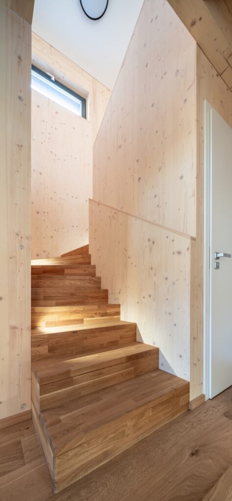 Schodiště s dřevěnými stěnami a podlahou v interiéru dřevostavby
