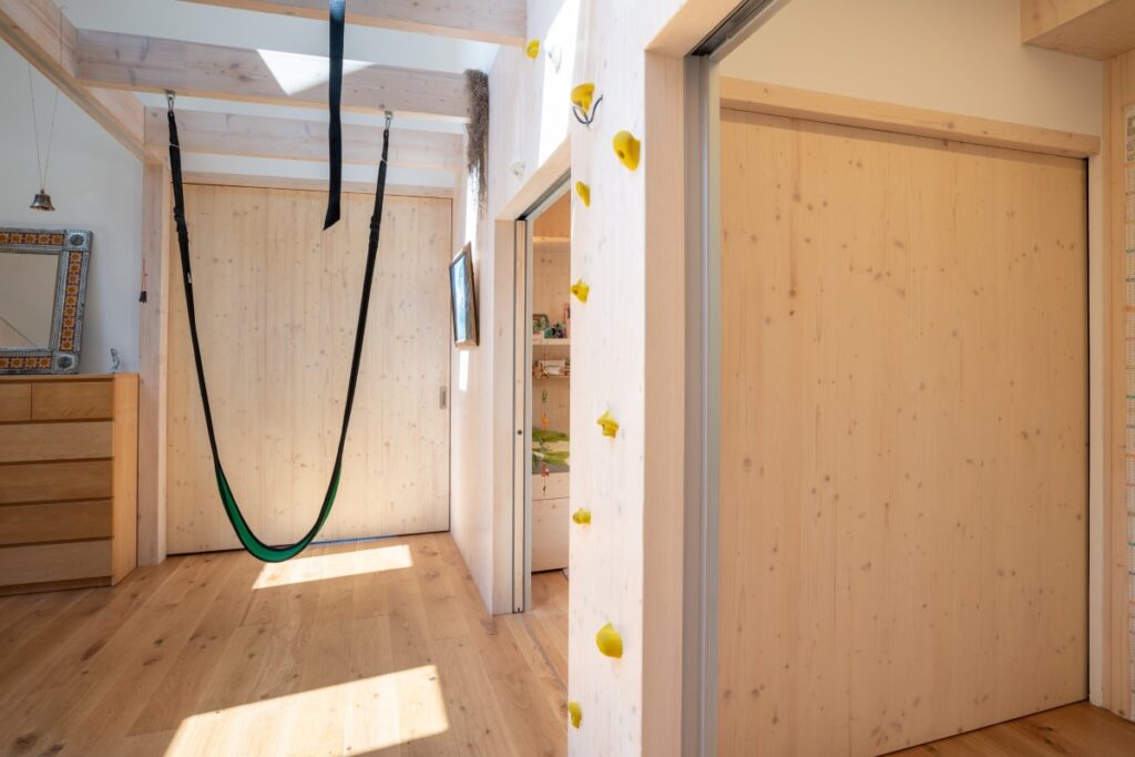 Chodba s houpací sítí, posuvnými dveřmi a CLT stěnami