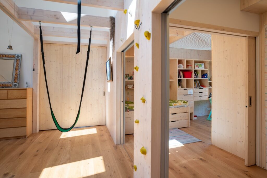Dětský pokoj s houpací sítí, horolezeckou stěnou a CLT obkladem