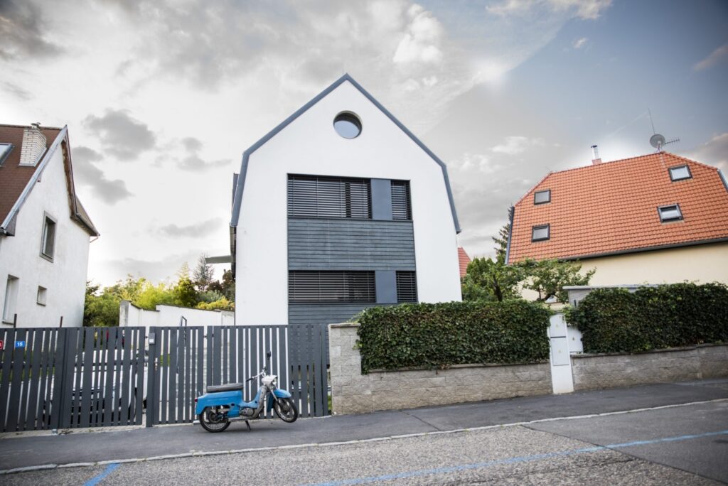 Městská patrová dřevostavba s černobílou fasádou a sedlovou střechou