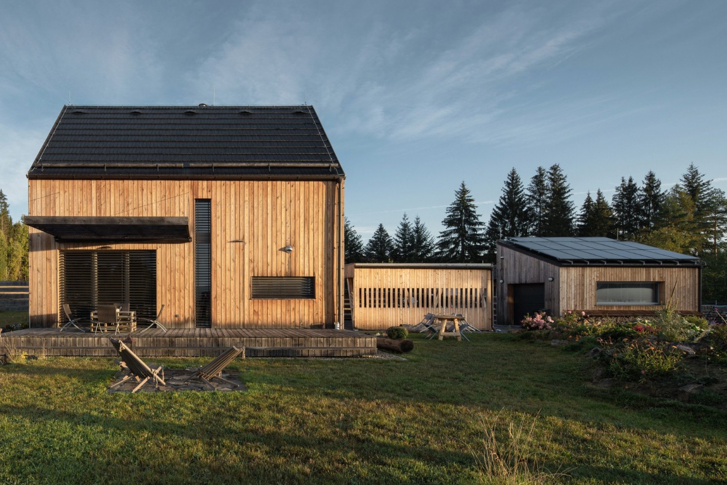 Dřevostavba se sedlovou střechou, přístavkem a fotovoltaikou na garáži - ilustrační foto ke článku blogu na téma cena projektu