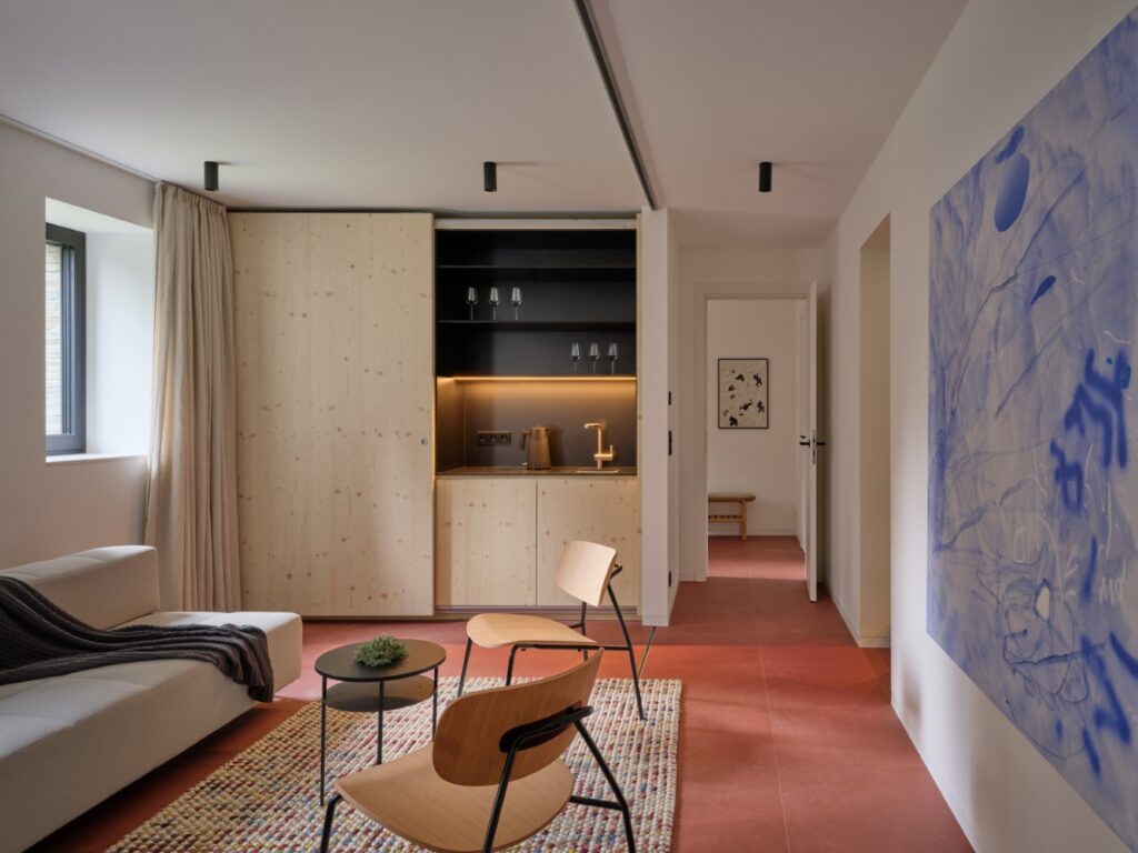 Moderní obytný prostor se zabudovaným nábytkem, dřevěnými prvky a bílými stěnami