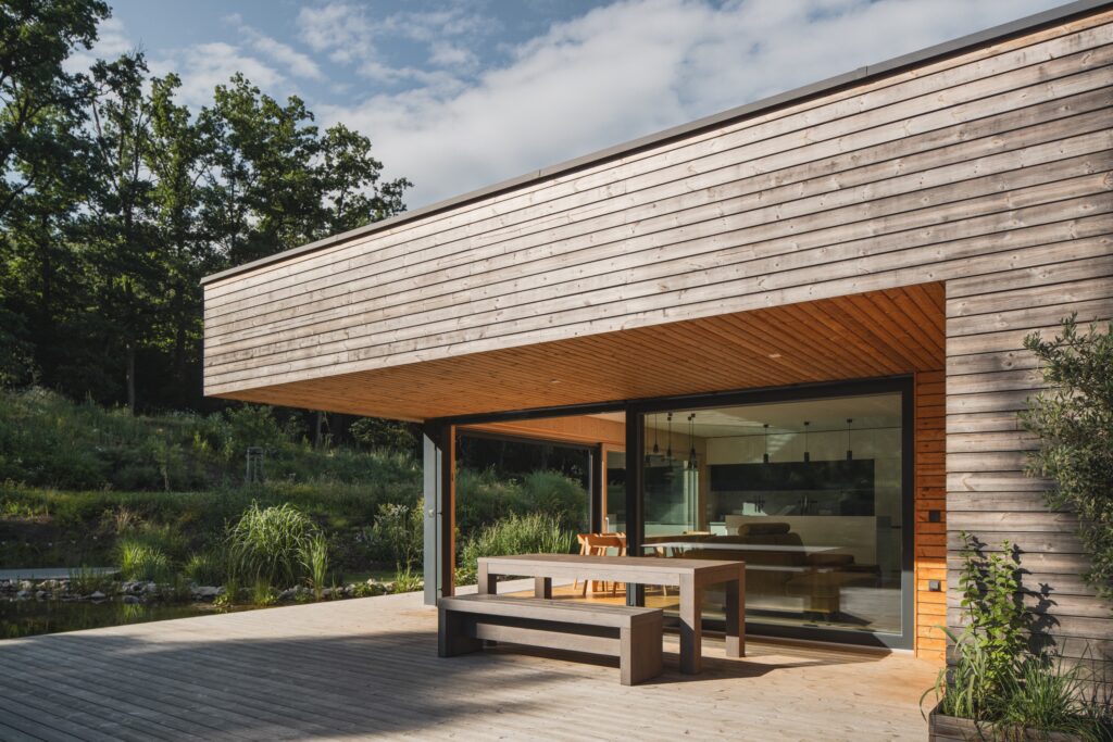 Moderní přízemní dřevostavba s prosklením a dřevěnou terasou