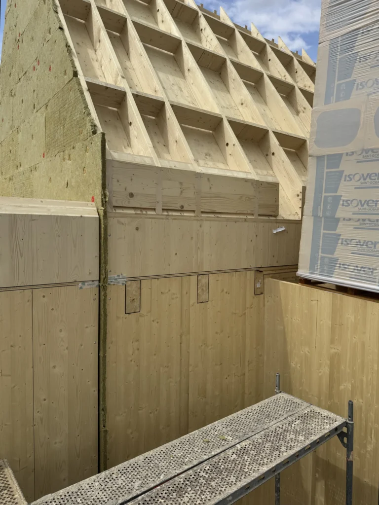 Detail napojení masivních CLT stěn a střešní konstrukce NOVATOP Open s vloženou tepelnou izolací při výstavbě domu Za lány.