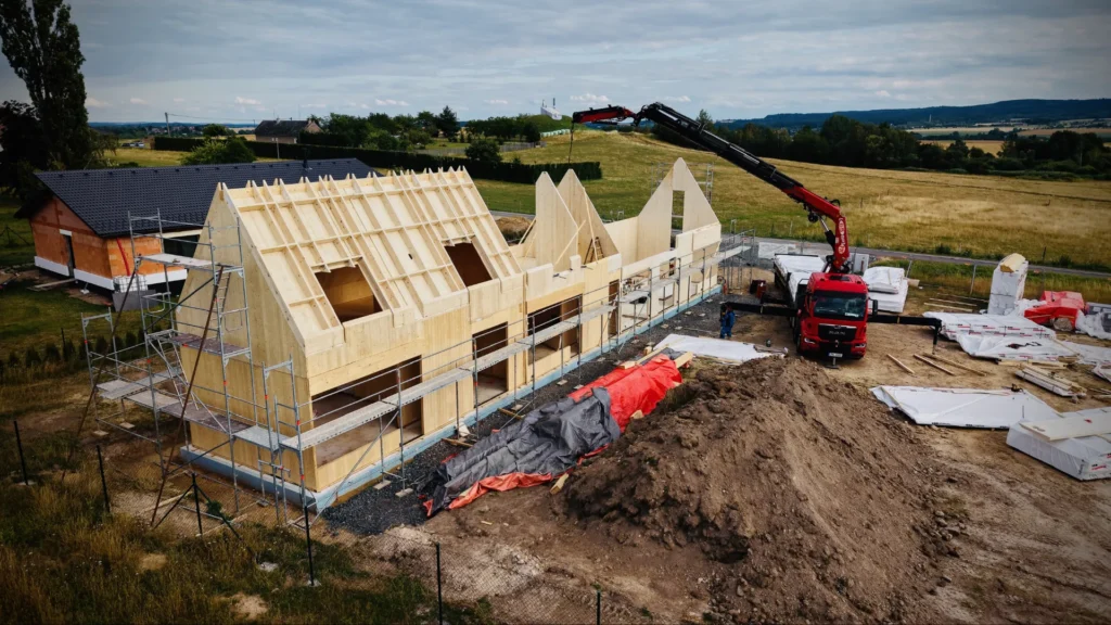 Rozestavěná nosná konstrukce domu Za lány z panelů NOVATOP během jeřábové montáže stěn a střechy.